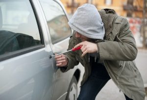 a man trying to forcibly unlock a car door