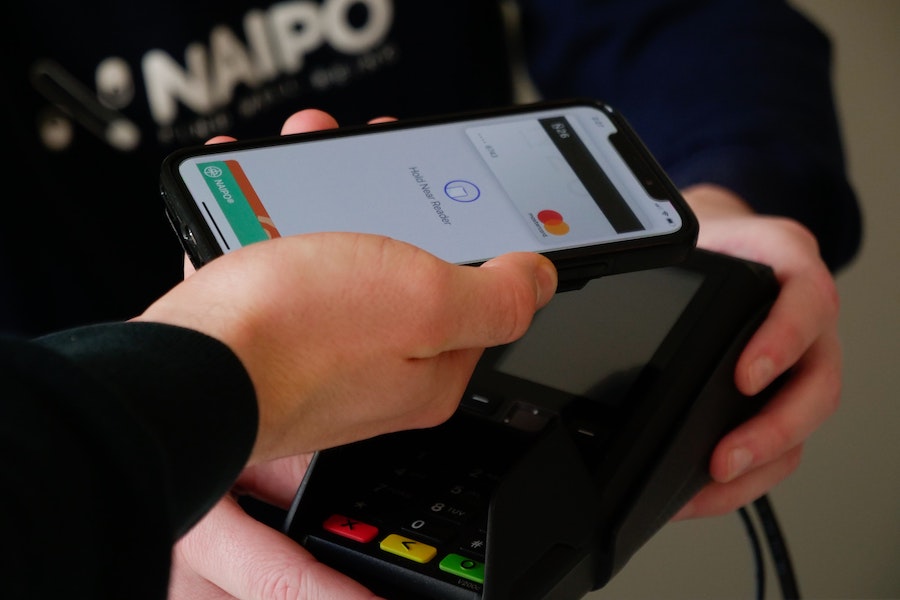 Person pays for a transaction using a card stored on their iPhone.
