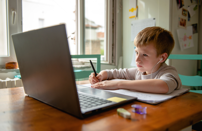 Young boy learning from home, online schooling