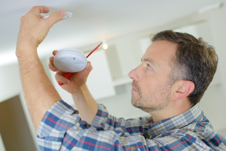 Electrician fitting a fire alarm