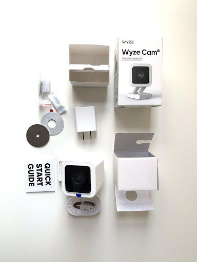 The contents included with Wyze Cam V3: the camera, micro USB cable and adaptor, charger, magnetic mounting disks, two screws and with wall plugs, alignment/mounting stickers, and Quick Start guide.