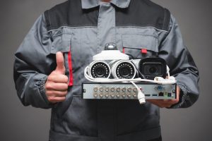 a man holding a wired security camera system