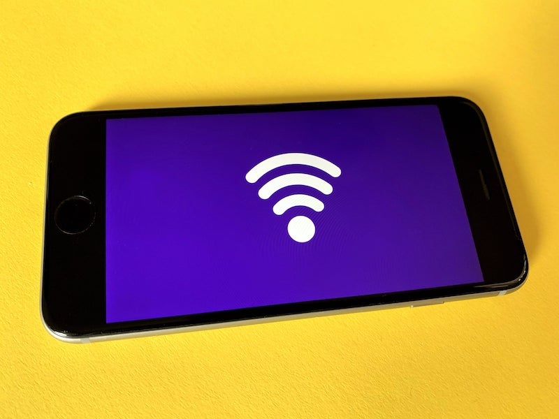 a wifi logo shown on a smartphone on a yellow background