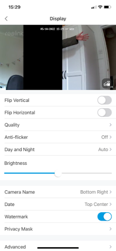 Using a privacy mask to black out part of the frame in the Reolink app (with a hand in the screen).