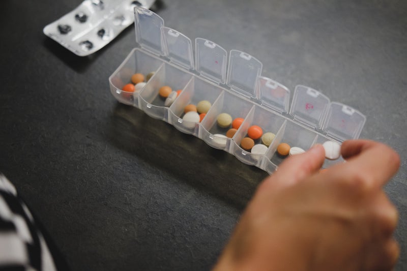 Person sorts pills into a pill box.