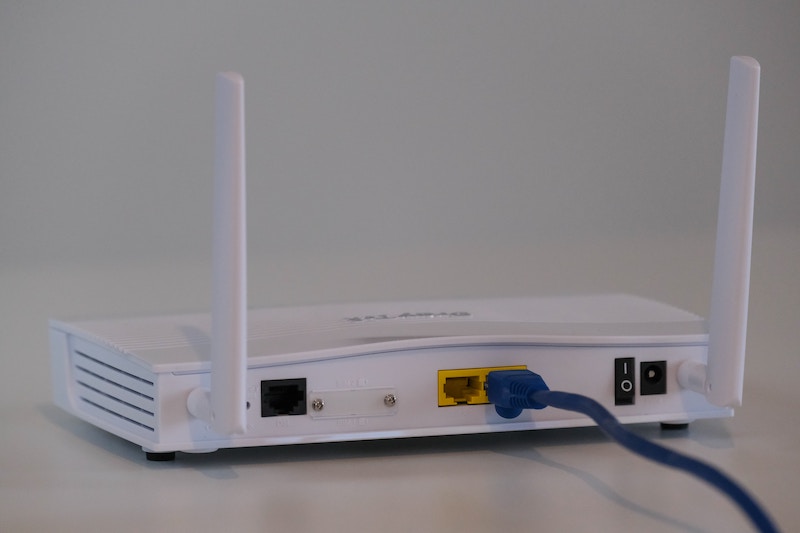 Broadband internet router with ethernet cable plugged in.