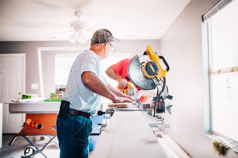 Two men completing renovation work in a home.