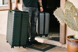 a man holding two luggages.