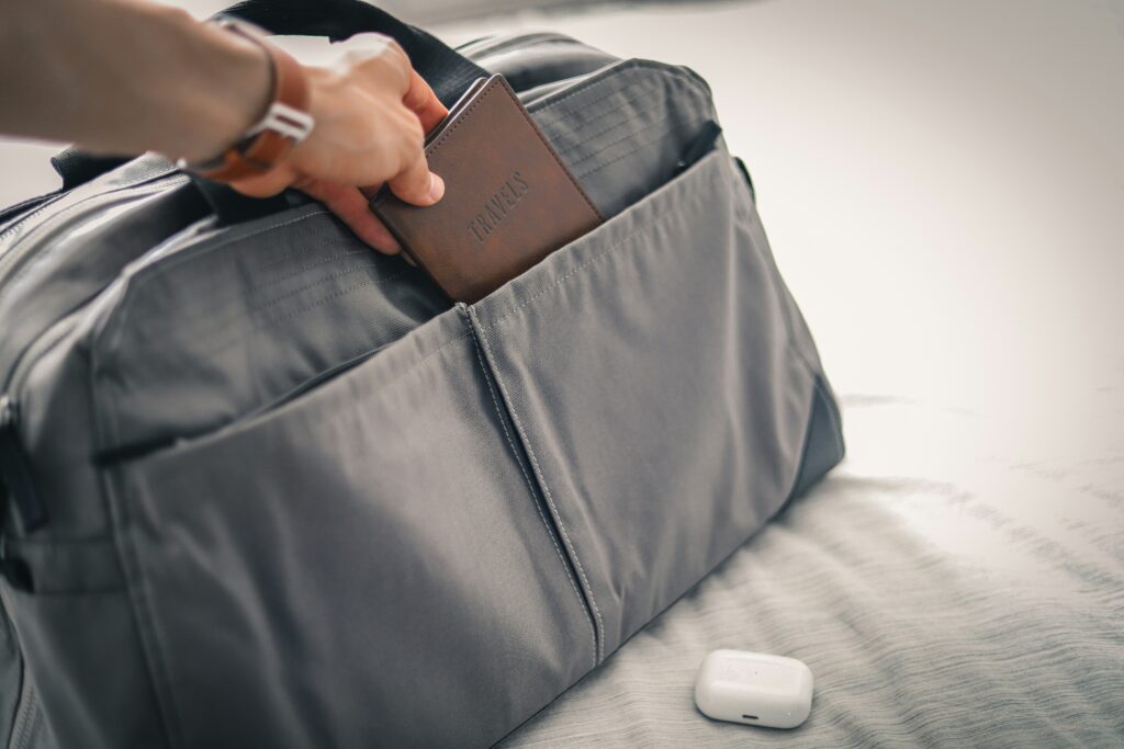 hand storing passport on luggage